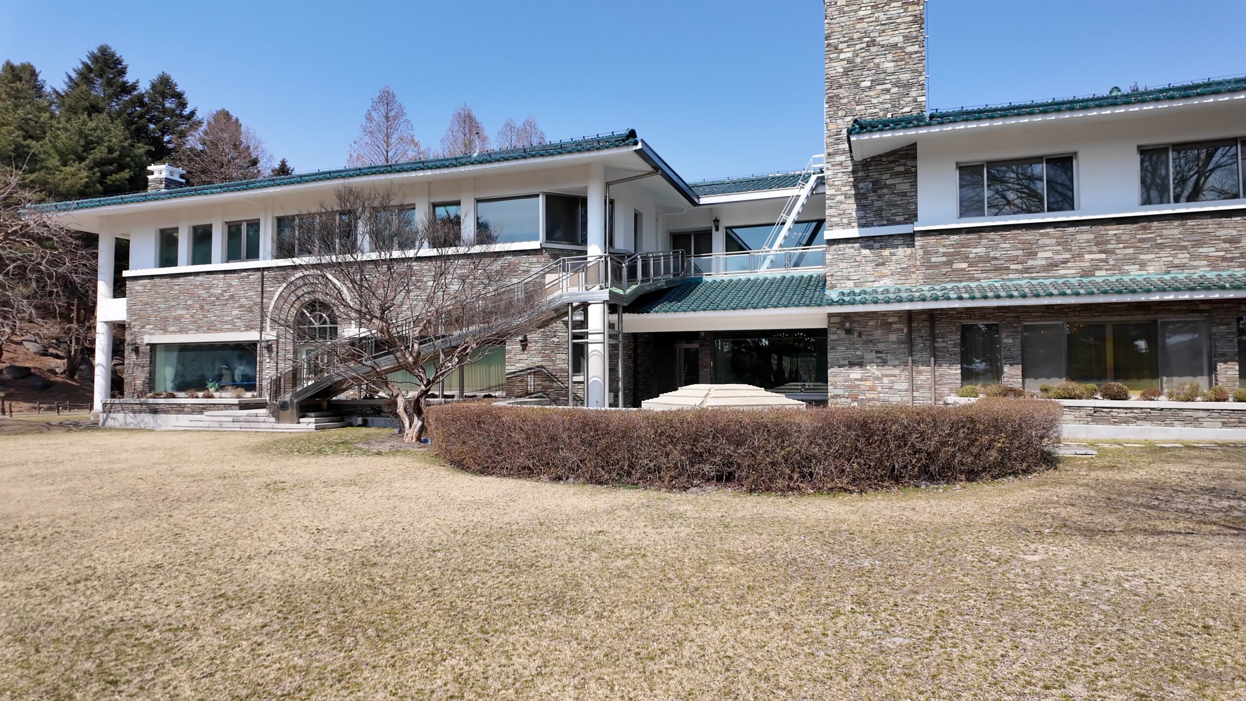 本館裏手の広大な芝生庭園と建物外観