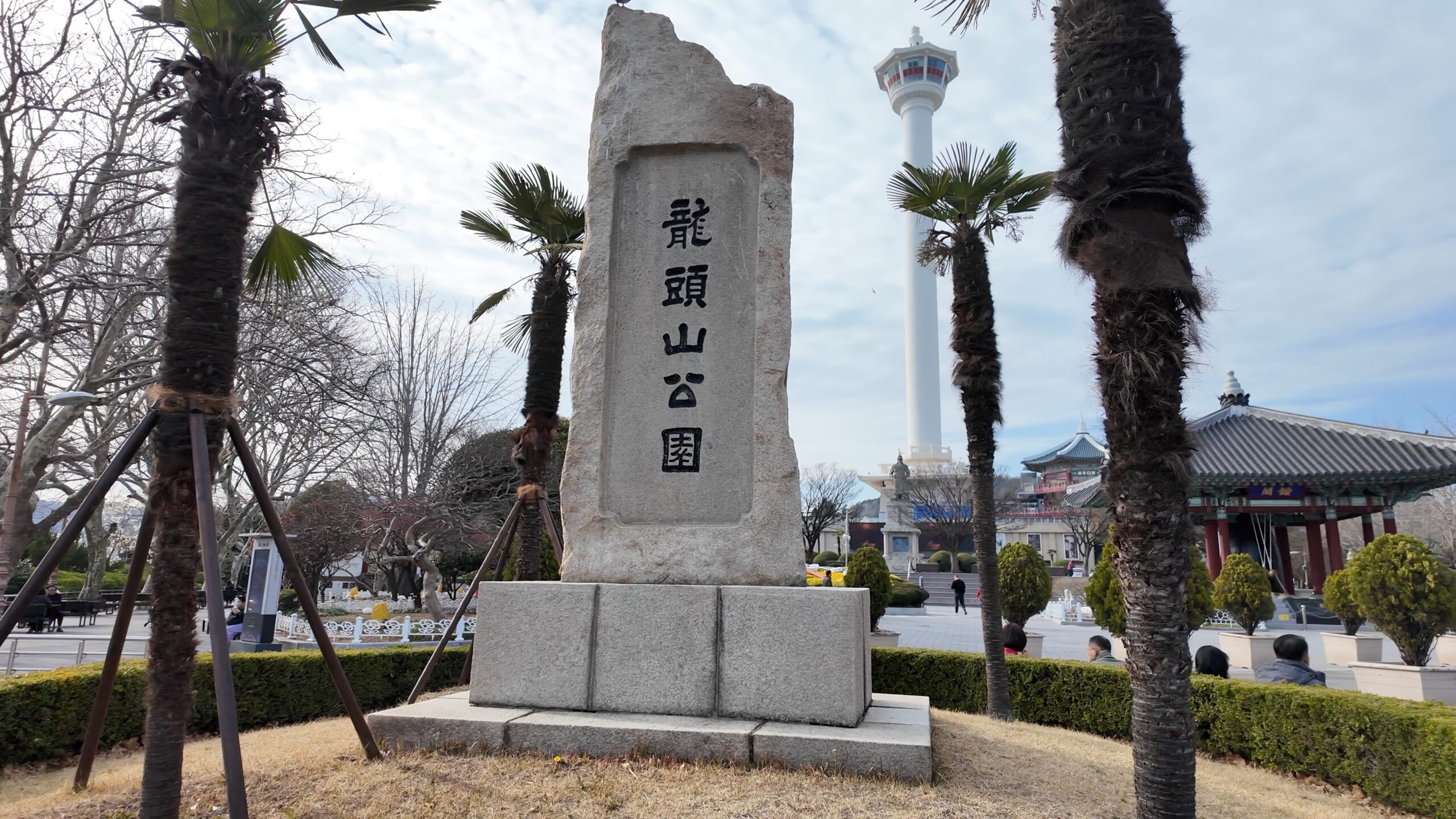 龍頭山公園の石碑と奥にそびえる釜山タワー