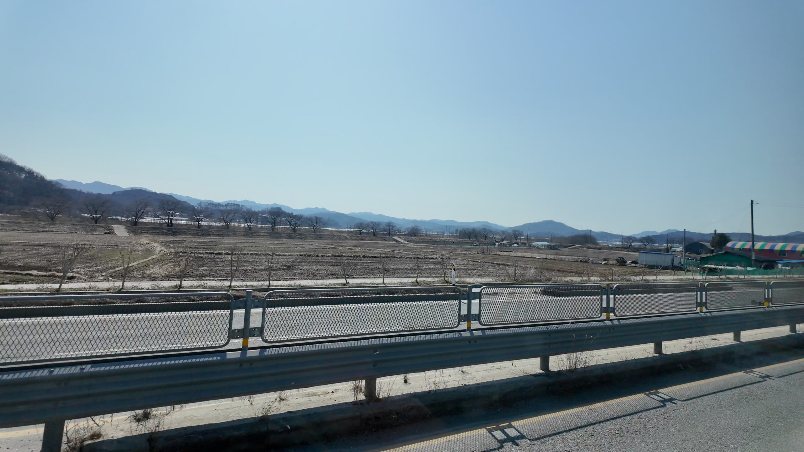 郊外ののどかな田園風景が広がる車窓