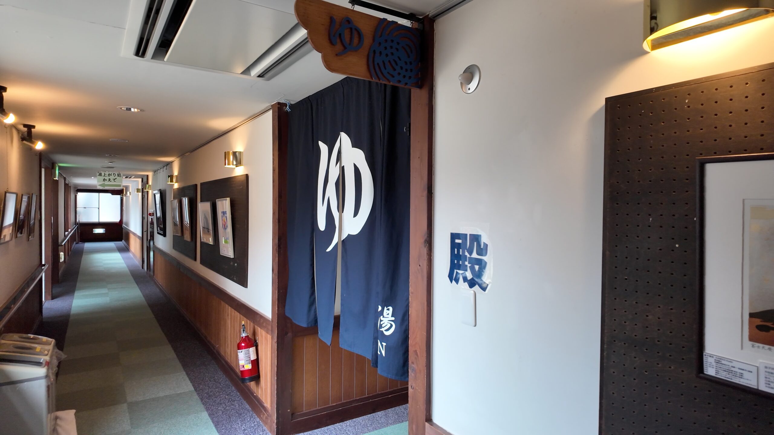 小菅の湯の落ち着いた和風の館内通路と男湯の暖簾