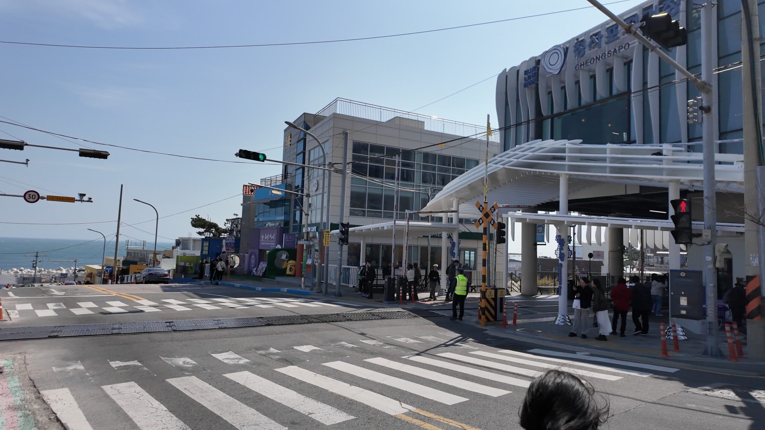 海の見える坂道が美しい青沙浦駅前の踏切