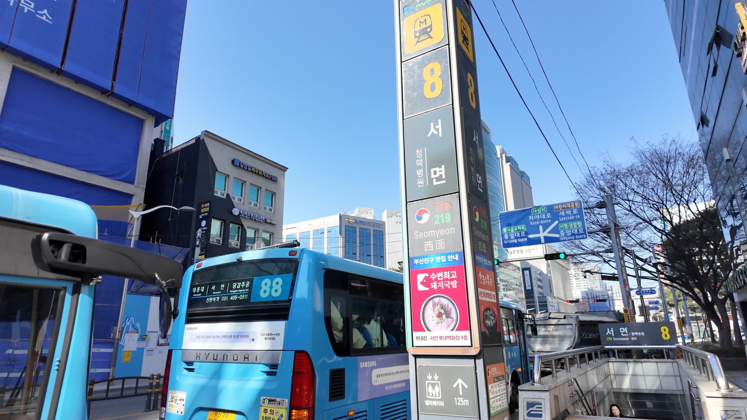 快晴の西面駅8番出口付近の街並みとバス停