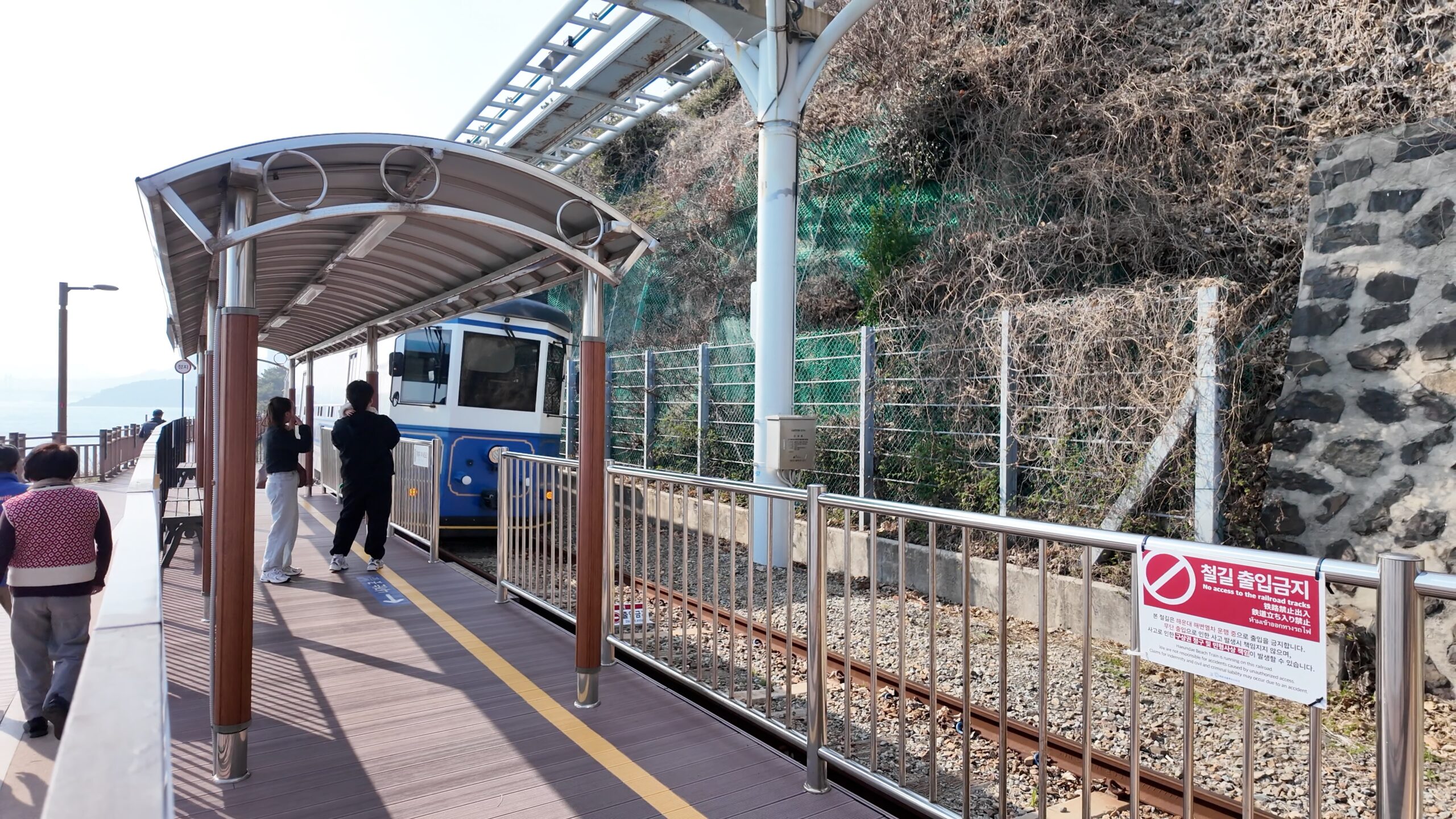 尾浦方面へ向かう遊歩道と途中駅に停車するビーチトレイン