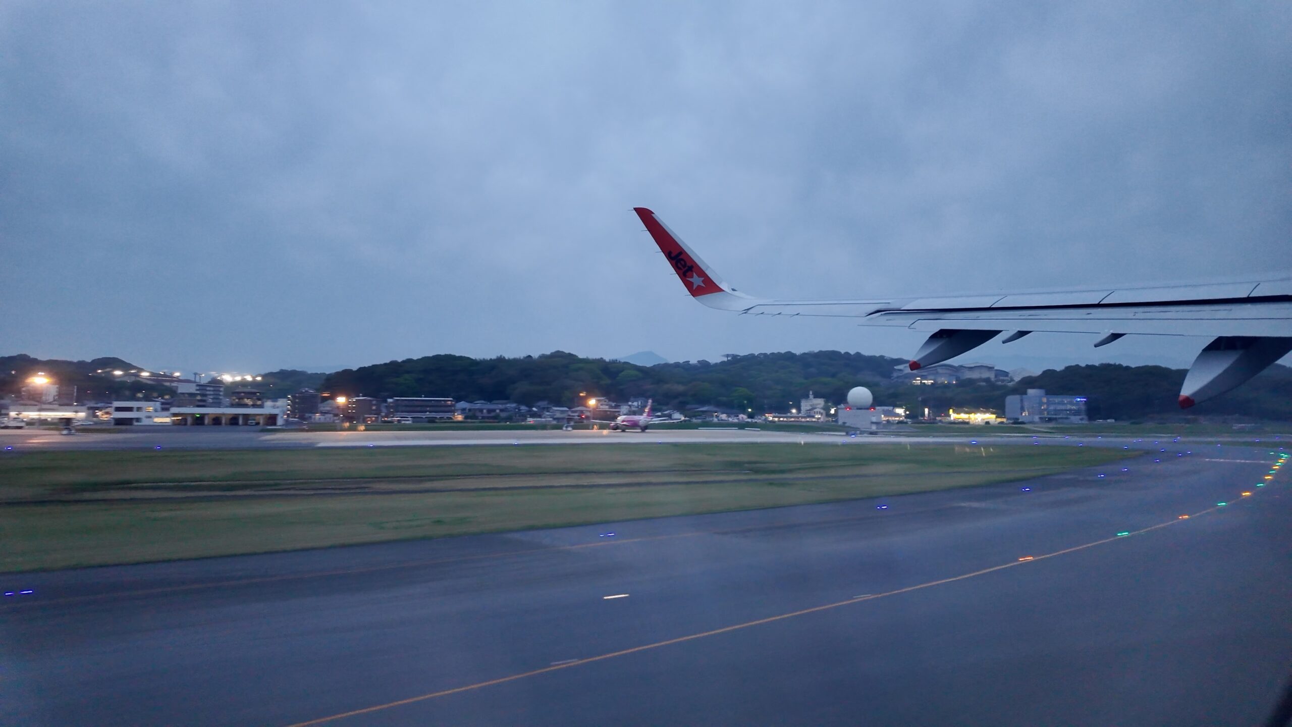 夕暮れの福岡空港から滑走路へ向かう機内からの眺め